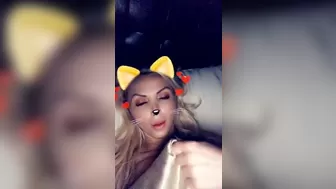 Nikki Benz lying on a white sofa and masturbating